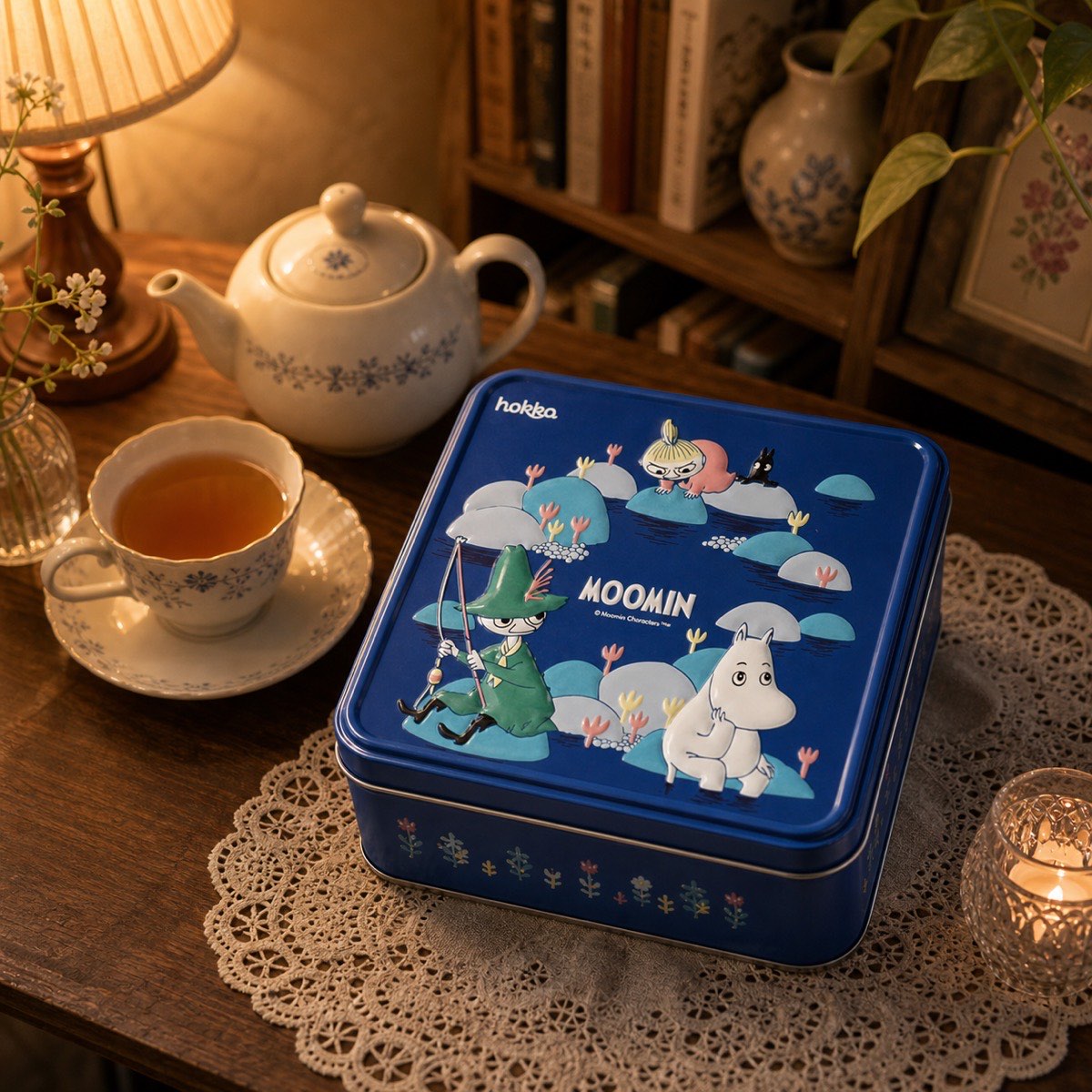 青い缶を添えるミルク味のお茶時間